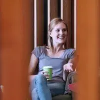 Three students seated while talking to each other.