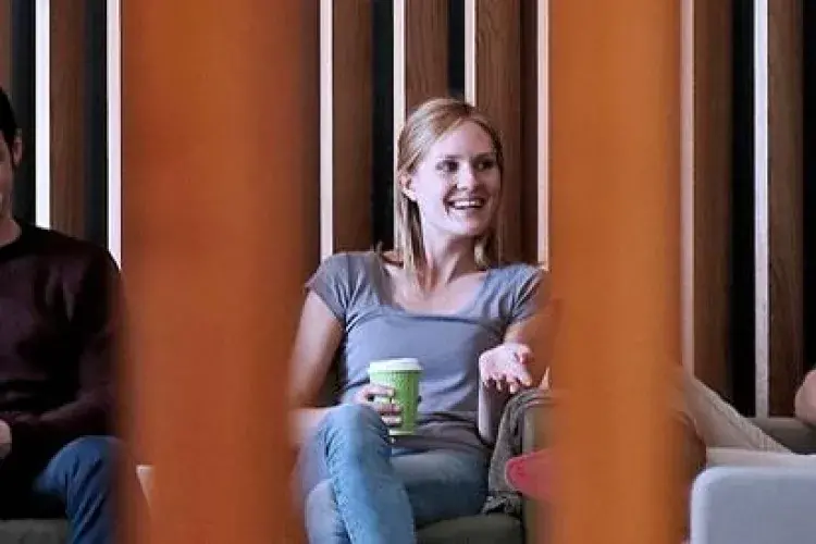 Three students seated while talking to each other.